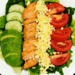 A vibrant salad with grilled chicken, tomatoes, and mixed greens.