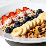 dairy-free dessert bowl with coconut milk, granola, and mixed berries