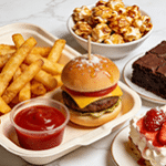 Assorted snack platter with cheeseburger, fries, popcorn, and chocolate brownie.