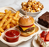 Assorted snack platter with cheeseburger, fries, popcorn, and chocolate brownie.